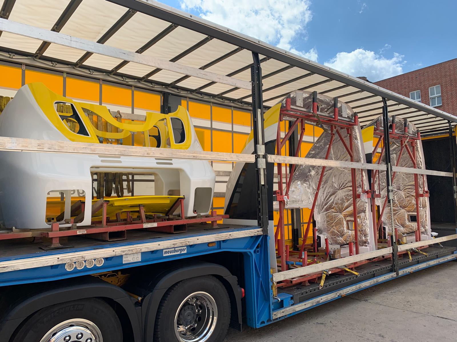 Tieflader beladen mit fertig lackierten Zugfronten und folierten Kabinen